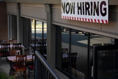 A "Now Hiring" sign is seen outside a restaurant in Arlington, Virginia. (Photo by OLIVIER DOULIERY/AFP via Getty Images)