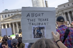 A pro-abortion demonstrator holds a sign reading "Abort the Texas Taliban" and featuring a photo of Texas Gov. Greg Abbott. (Photo credit: Andrew Lichtenstein/Corbis via Getty Images)