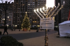 A menorah lit for the passing nights of Hanukkah and a Christmas tree stand in Madison Square Park. (Photo credit: John Lamparski/Getty Images)