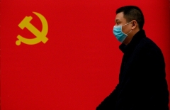 A man passes a Communist Party flag in Wuhan on March 31, 2020. (Photo by Noel Celis/AFP via Getty Images)
