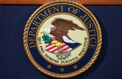 The Department of Justice seal is seen on a lectern ahead of a press conference. (Photo credit: MANDEL NGAN/AFP via Getty Images)