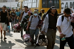 Migrants heading in a caravan towards the US wait for buses at the "House of the Pilgrim San Juan Diego" in Mexico City, on December 22, 2021. - Central American migrants will be transported to the cities of Monterrey, Juarez and Hermosillo. There, with the help of the authorities of the National Institute of Migration, they can continue their immigration procedures and can wait to enter to the United States. (Photo by ALFREDO ESTRELLA/AFP via Getty Images)