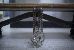 Pictured are handcuffs chained to a bench. (Photo credit: Robert Nickelsberg/Getty Images)