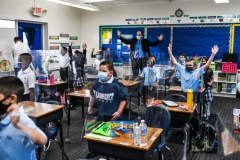 The new Superintendent of Schools for the Archdiocese of Miami, Jim Rigg (behind) dances with students wearing facemasks as they attend their first day in school after summer vacation at the St. Lawrence Catholic School in north of Miami, on August 18, 2021. (Photo by CHANDAN KHANNA/AFP via Getty Images)