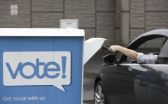 A voter submits a mail-in ballot. (Photo credit: JASON REDMOND/AFP via Getty Images)