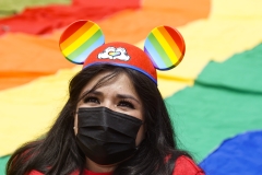 A woman wears LGBT-themed Mickey Mouse ears during a gay pride parade. (Photo credit: APHOTOGRAFIA/Getty Images)