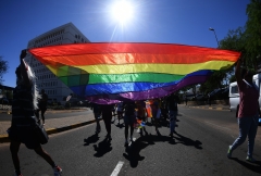 Individuals carry an LGBT Pride flag. (Photo credit: MONIRUL BHUIYAN/AFP via Getty Images)