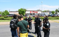 Police and mourners gather near a Tops Grocery store in Buffalo, New York, on May 15, 2022. - Grieving residents from the US city of Buffalo held vigils Sunday after a white gunman who officials have deemed "pure evil" shot dead 10 people at a grocery store in a racially-motivated rampage. (Photo by USMAN KHAN/AFP via Getty Images)