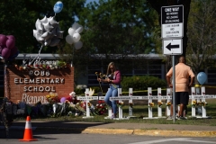 People drop off flowers at a makeshift memorial outside the Robb Elementary School on May 26, 2022 in Uvalde, Texas. (Photo by ALLISON DINNER/AFP via Getty Images)
