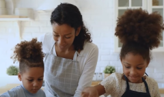 A black mother helps children in the kitchen. (Photo credit: YouTube/Thomas Sowell IDEAS)