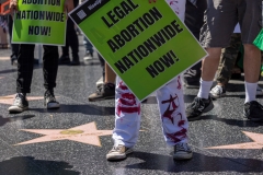 A protester standing on the stars of the Hollywood Walk of Fame wears pants with red paint, symbolizing the blood women who may hemorrhage during illegal abortions, during a protest to denounce the U.S. Supreme Court on July 9, 2022 in the Hollywood section of Los Angeles, California. (Photo by David McNew/Getty Images)