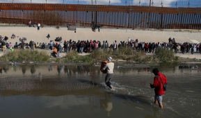 Migrants walk across the Rio Grande to surrender to US Border Patrol agents in El Paso, Texas, as seen from Ciudad Juarez, Chihuahua state, Mexico, on December 13, 2022. (Photo by HERIKA MARTINEZ/AFP via Getty Images)