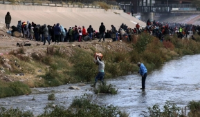 Migrants walk across the Rio Grande to surrender to US Border Patrol agents in El Paso, Texas, as seen from Ciudad Juarez, Chihuahua state, Mexico, on December 13, 2022. (Photo by HERIKA MARTINEZ/AFP via Getty Images)