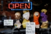 Mannequin heads wear masks in the window of a small boutique advertising availability of masks, gloves, and other pandemic necessities amid the Coronavirus outbreak in Arlington, Virginia, on April 27, 2020.  (Photo by OLIVIER DOULIERY/AFP via Getty Images)