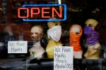 Mannequin heads wear masks in the window of a small boutique advertising availability of masks, gloves, and other pandemic necessities amid the Coronavirus outbreak in Arlington, Virginia, on April 27, 2020.  (Photo by OLIVIER DOULIERY/AFP via Getty Images)